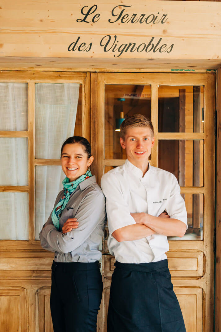 Les Chefs Judith et Alexandre devant l'enseigne de leur nouveau restaurant Le Terroir des Vignobles, à la Rosière