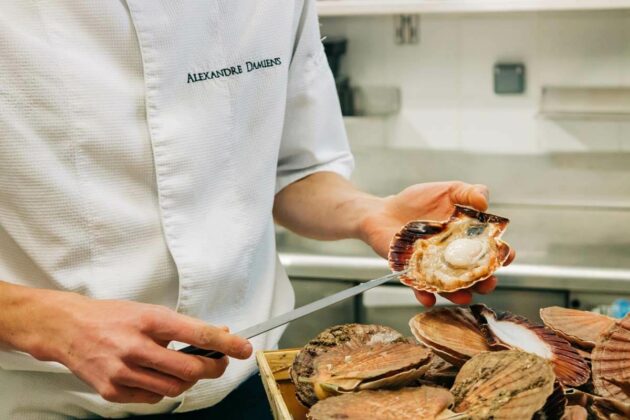 Le Chef Alexandre Damiens ouvrant des coquilles Saint-Jacques.