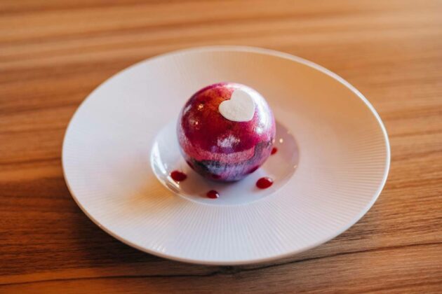 La Cranberry et chocolat, fine boule en sucre, crémeux chocolat, gelée hibiscus, émulsion et confit cranberry.