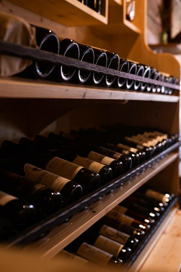 Étagère à vin rempli de bouteilles qui accommodera vos plats ou qui pourront être dégusté en terrasse.